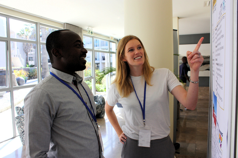 A HABVIA team member discussing a poster with a fellow HeatNexus member at the HeatNexus convening in Cape Town