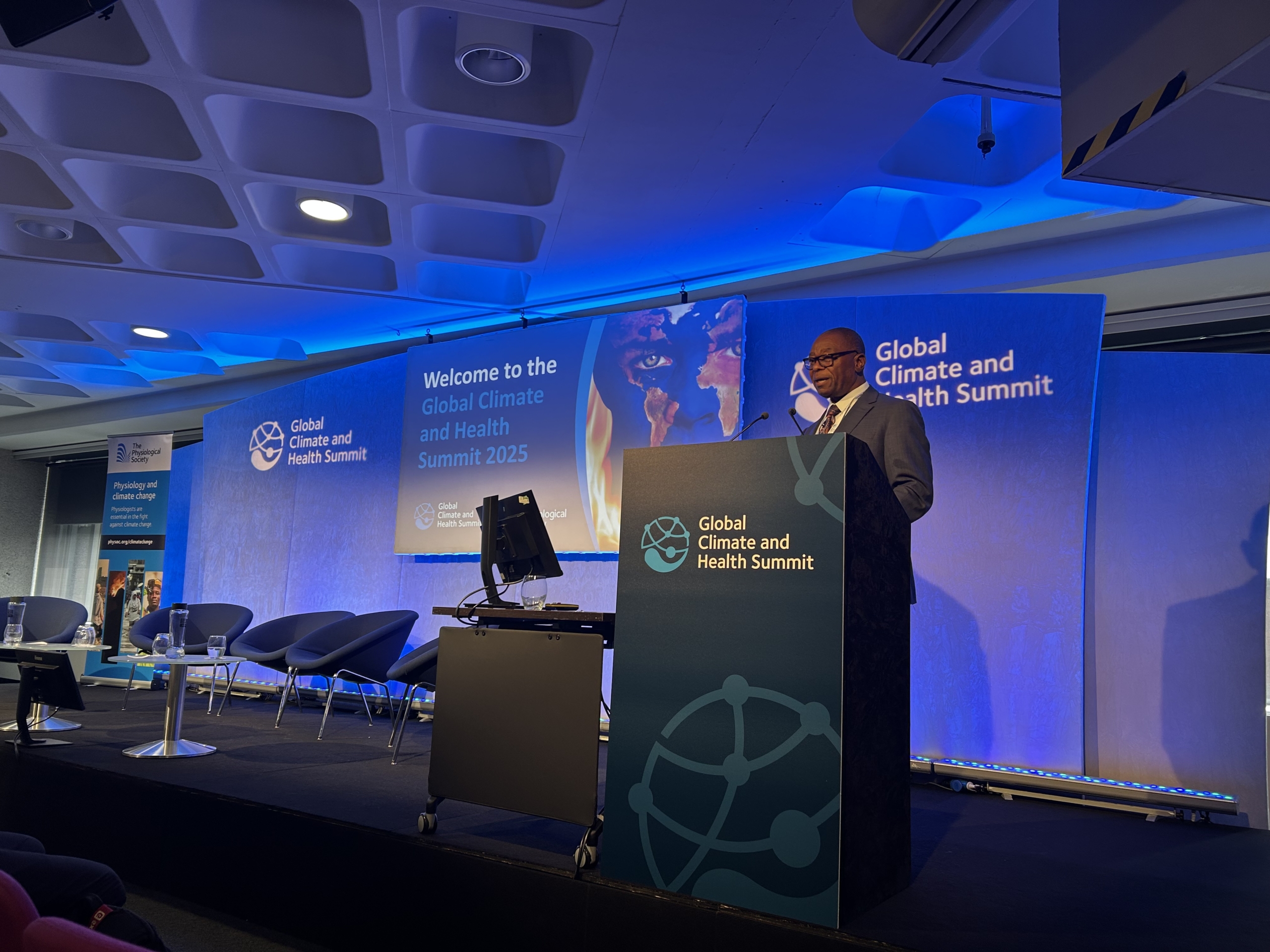 Dr Douglas Mombeshora, Zimbabwe’s Minister of Health and Child Care stands at a podium on the stage at the Global Climate and Health Summit in London
